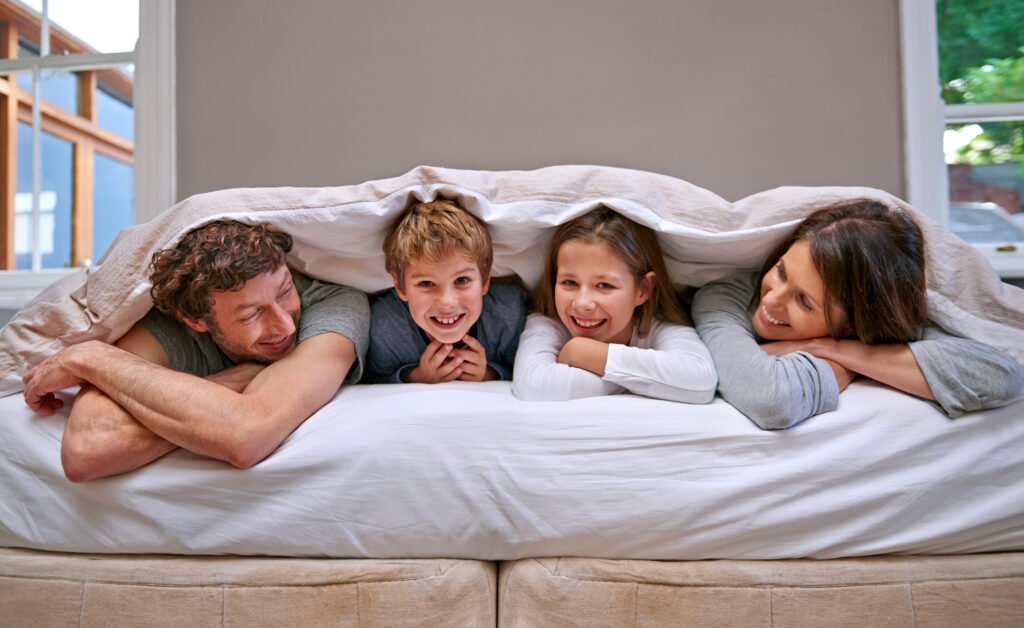 Shot of a happy family of four in the bedroom.